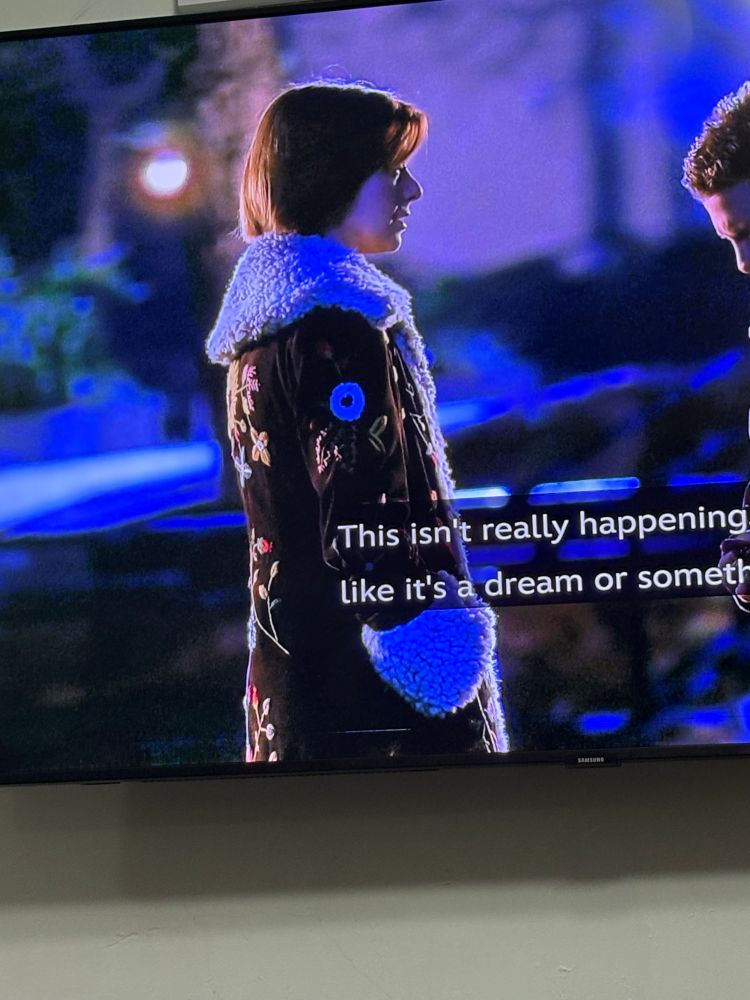 Willow from Buffy the Vampire Slayer wearing a brown coat decorated with flowers 