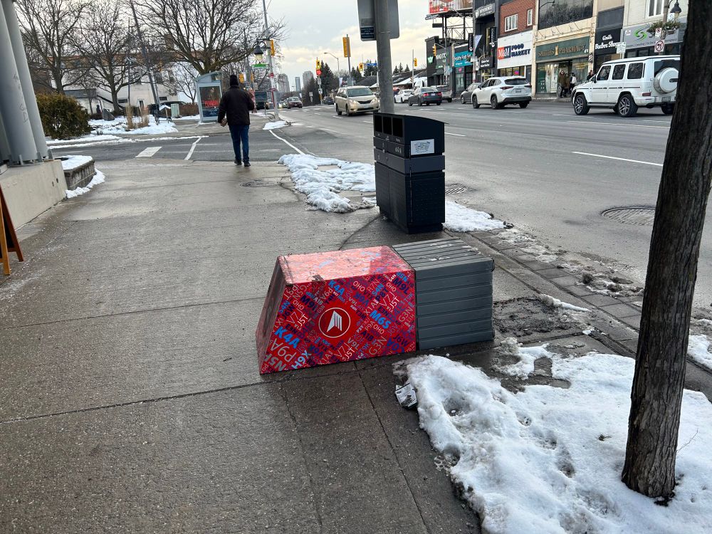 A Canada Post red mailbox is knocked over, drop slot down, in Toronto.