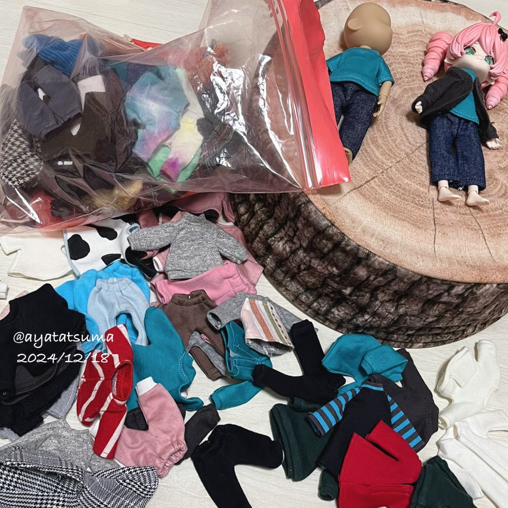 ドール服の試着風景。たくさん散らばったミニチュア服。
