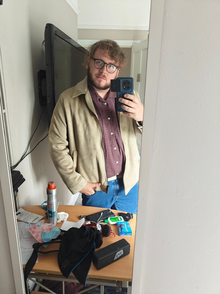 Mirror selfie wearing a cream jacket over a burgundy shirt