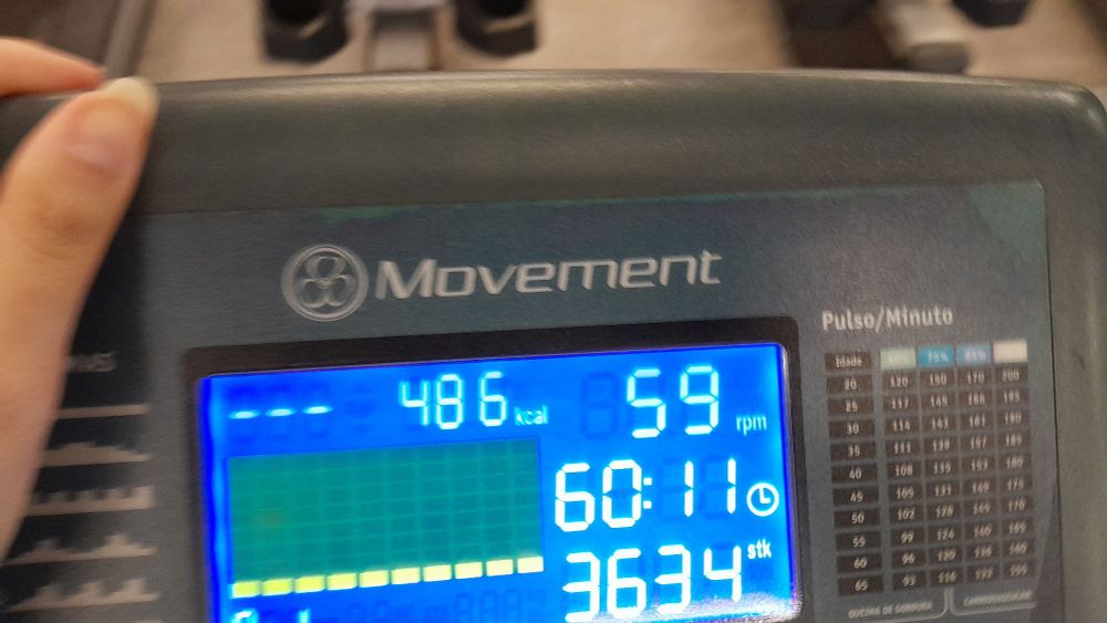 Foto do painel de uma máquina de elíptico mostrando 486kcal, 59rpm, tempo de 60:11 e 3634 passos dados.
