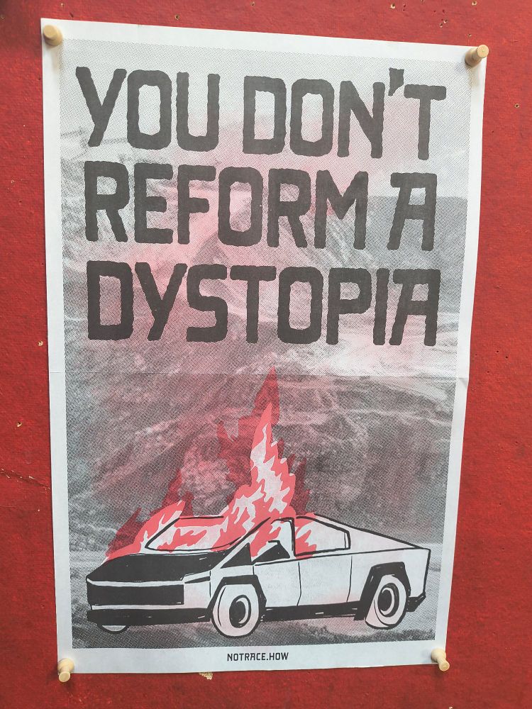 Red and black print of a burning cybertruck with the text "You don't reform a dystopia."