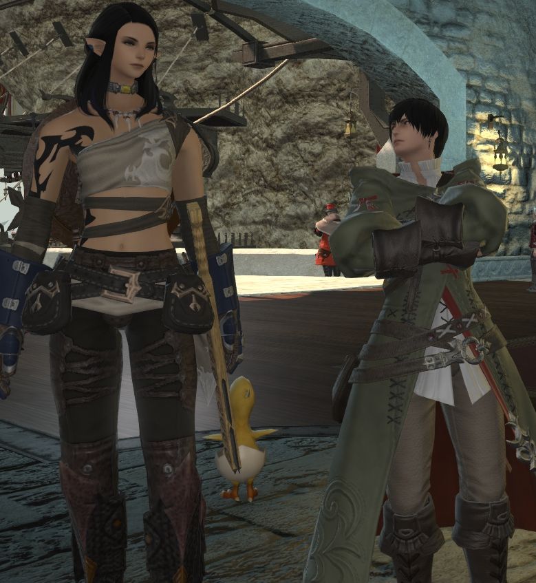 Raedan (dark haired Hyur, right) looks very seriously at freshly Fantasia'd Ètoile (dark haired Elezen, right). 
She is now a feminine Elezen with long wavy dark hair, and looks much happier than the previous picture.