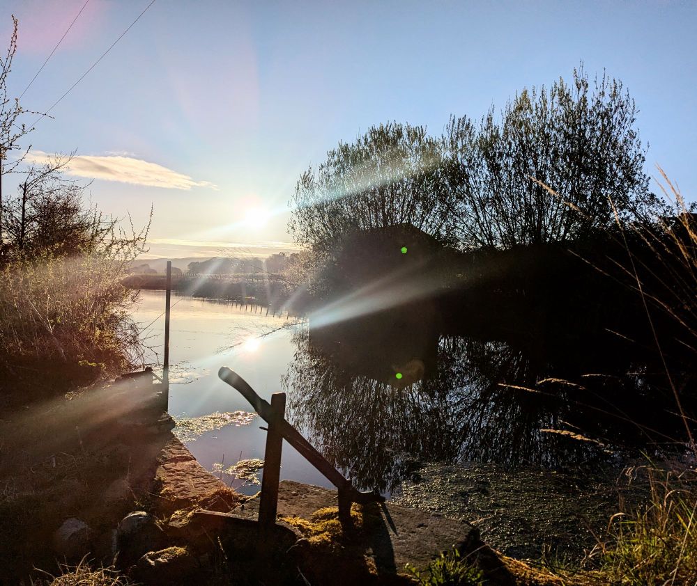 Millpond with bright sun shadows and bluesky