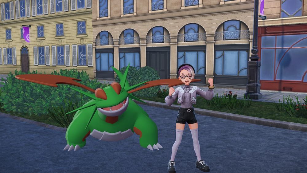 Shiny alpha Salamance and its trainer cheering and smiling at the camera. 