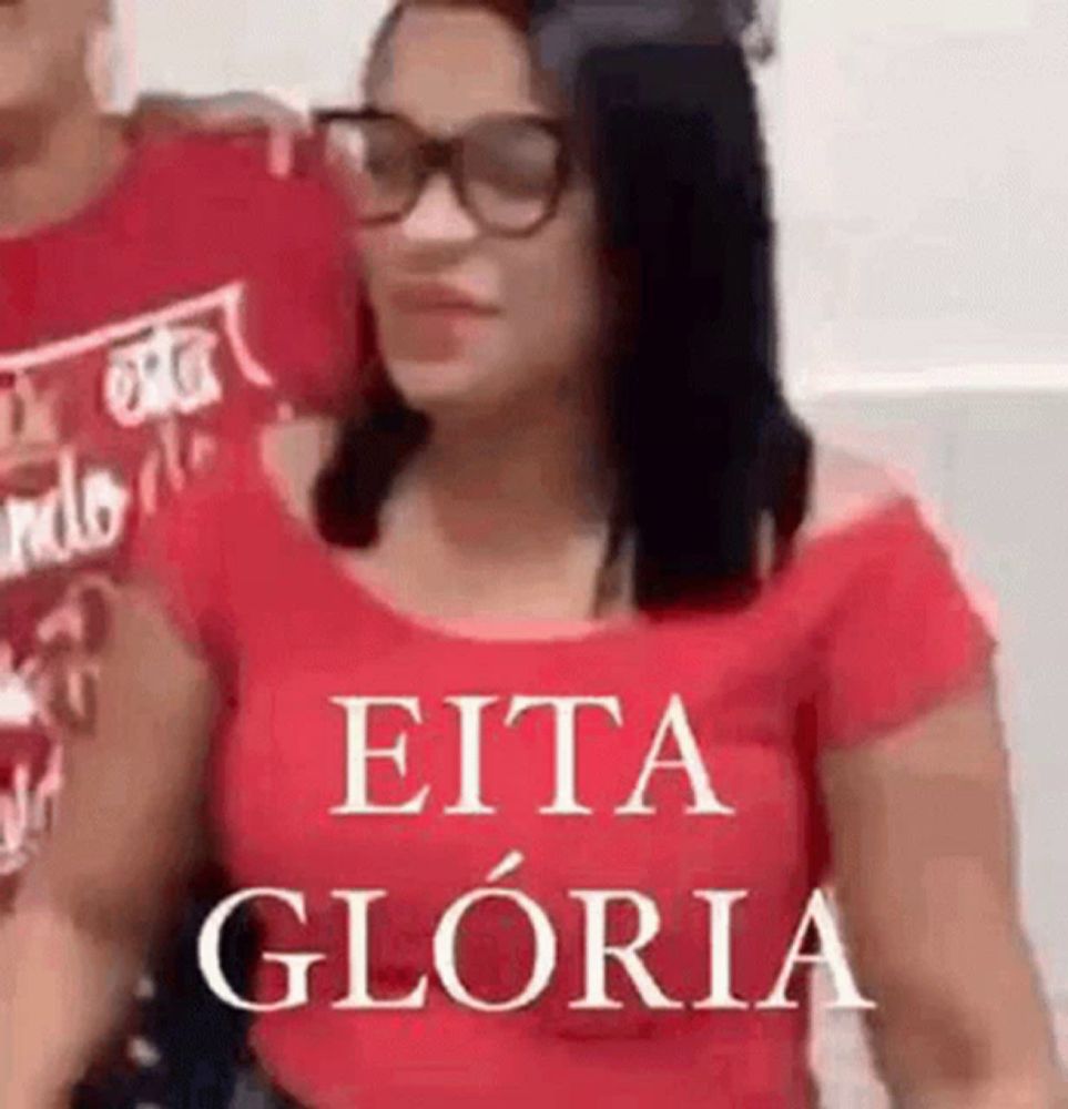 a woman wearing glasses and a red shirt with the words eita gloria written on it .