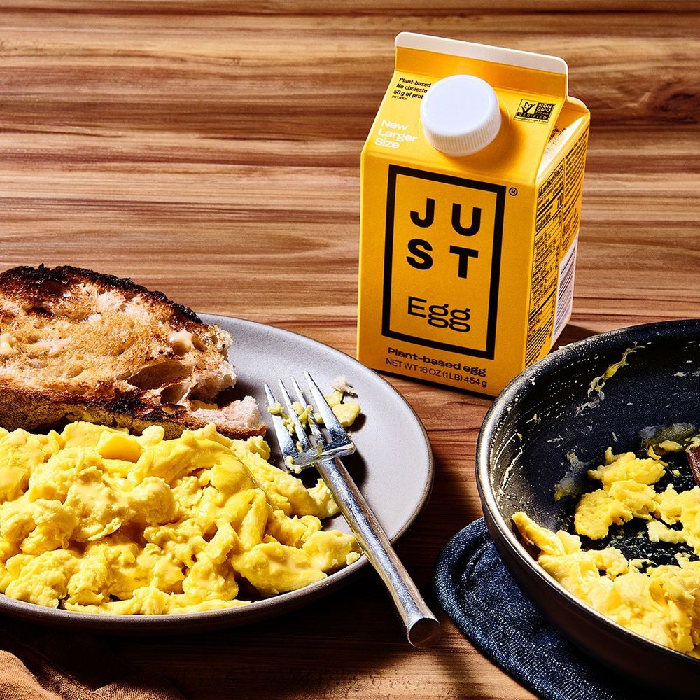 A promotional advertising photo for JUST EGG. A photo of the yellow product carton next to a plate with toast and eggs. In the photo the eggs look tasty and normal. In reality they were neither of those things.