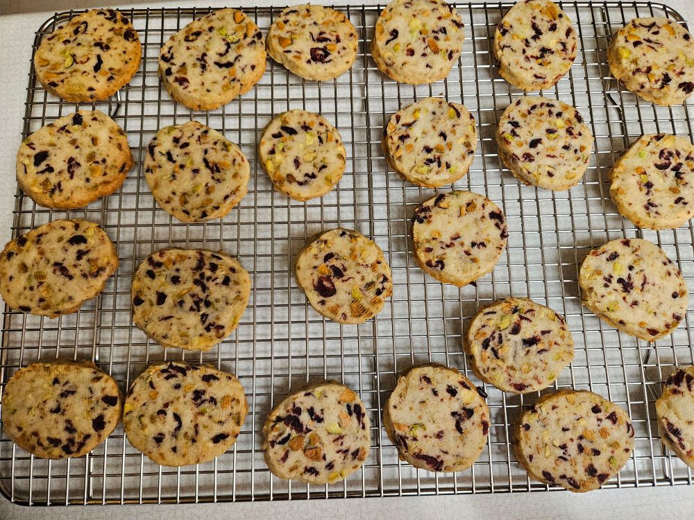 cranberry orange pistachio shortbread cookies on a cooling rack