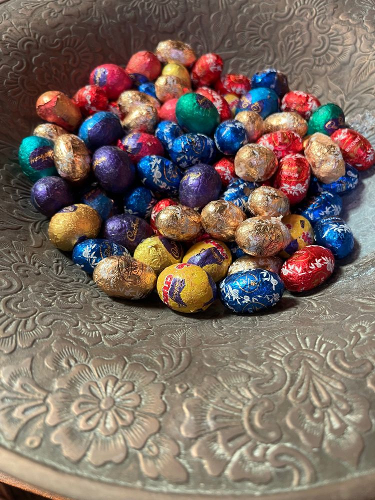 A brass bowl full of mini Easter eggs. 