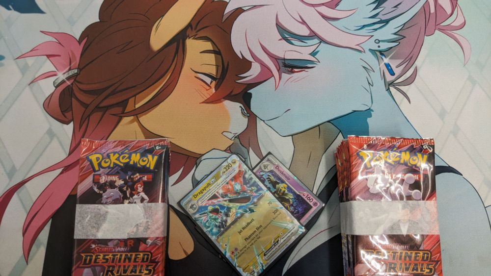a picture of my playmat, my pack winnings, and a Dragapult ex and dusknoir laid on top of each other to make a heart
