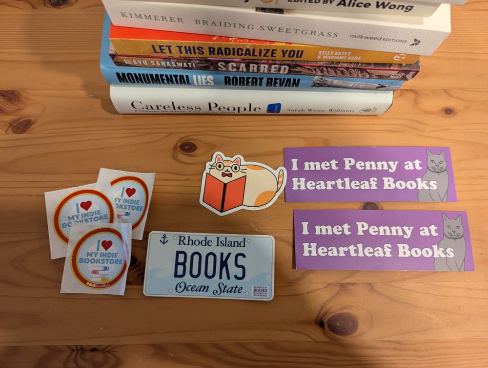 Another picture of the haul form the bookstore. I have 2 "I met Penny at Heartleaf Books" bookmarks with Penny pictured. A cute sticker of a cat with a book. A Rhode Island license plate sticker with BOOKS on it. And 3 I ❤️ my indie bookstore stickers for indie bookstore day