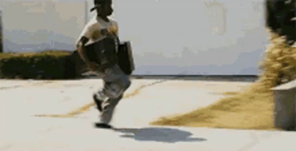 a man is running down a sidewalk with a briefcase