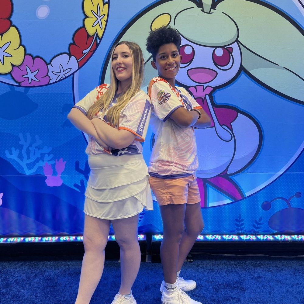 a photo of Steph and Vee standing next to each other at Worlds in Honolulu. Feeling Grateful to Pokémon for providing us both with free access to the event this year!