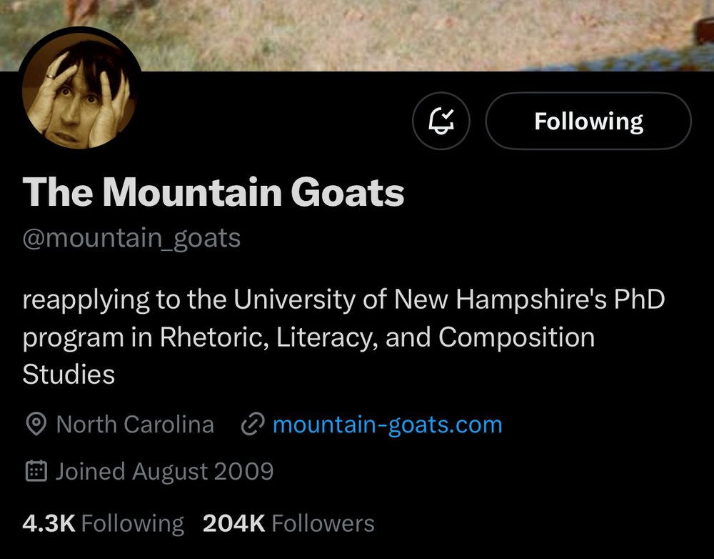 @mountain_goats twitter landing page featuring (personally) glaring annotated bio status-partial; reading, ‘reapplying to the university of new hampshire's phd program in rhetoric, literacy, and composition studies.’