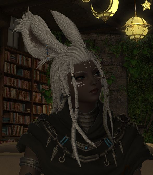 A Final Fantasy 14 character named Freja Hyskaris, of dark complexion, light braided hair, similarly colored short ears, and dark green eyes. 
She is facing towards her side, away from the viewer, with a mildly judgemental stare.
She has a black top with metal adornments and wears white face paint.
