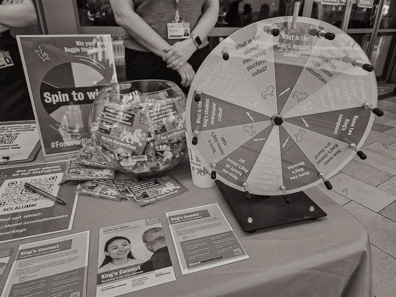 A black and white photo of the alumni booth at graduation.