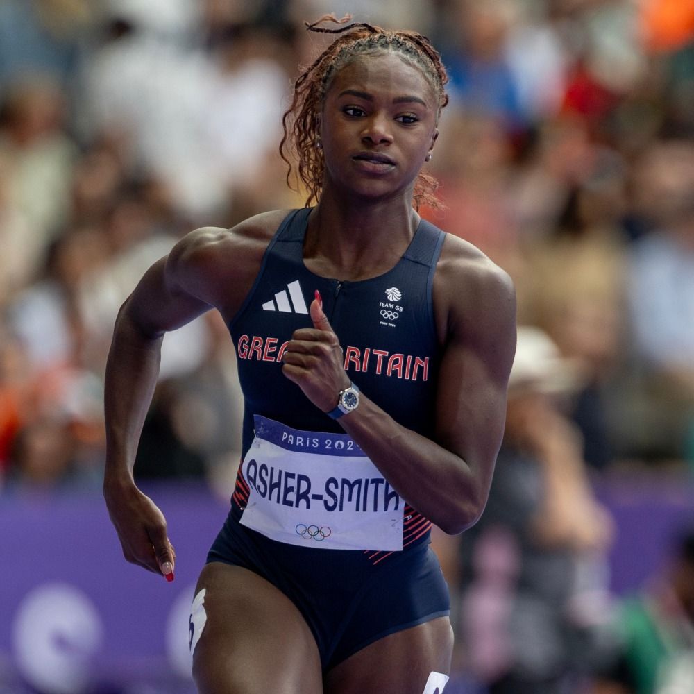 A young woman in a Great Britain athletics top with the name 'Asher-Smith' printed on it competes in the 200m at the Olympics.