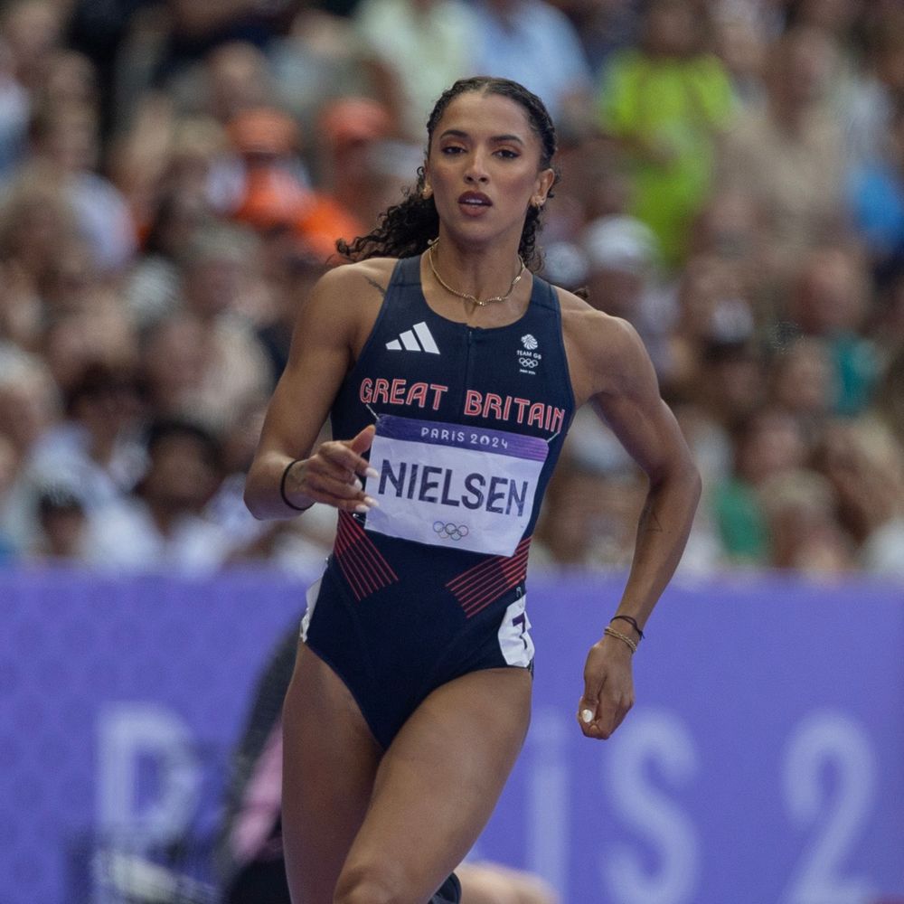 A young woman in a Great Britain athletics top with the name 'Nielsen' printed on it competes in the 400m at the Olympics.