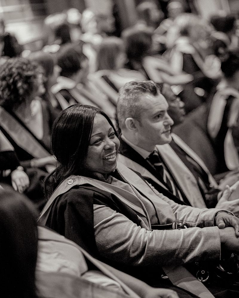 Black and white picture of students sitting in a graduation hall.