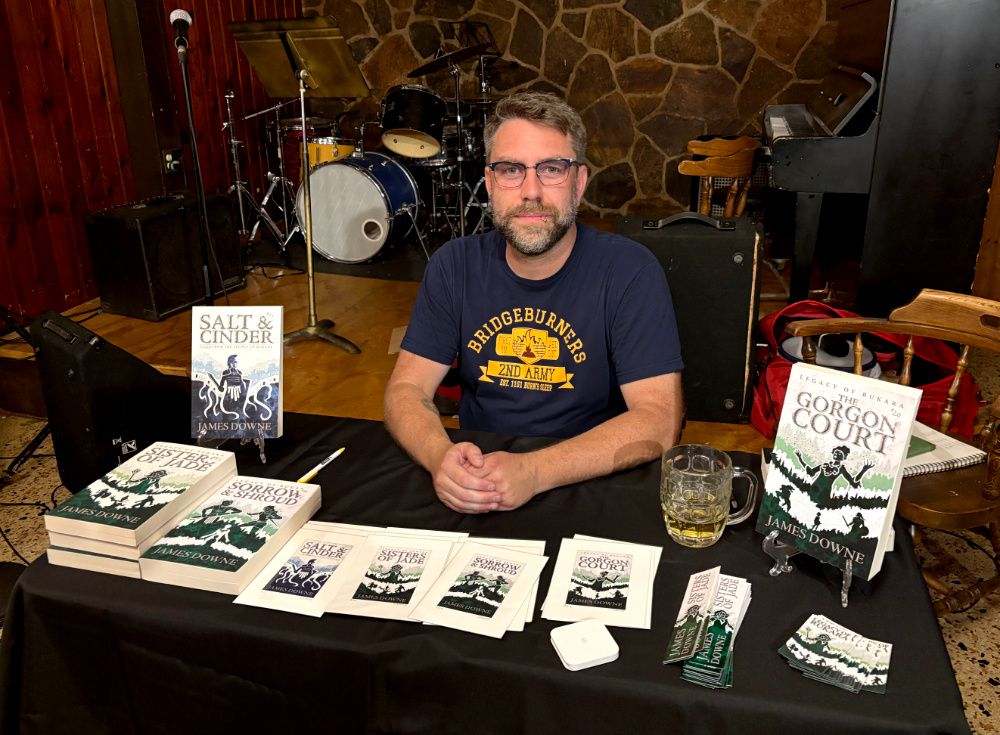 A man (me) sitting at a table with books arranged before him.