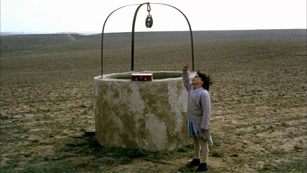 Scène du film "L'esprit de la ruche" ("El espíritu de la colmena" en VO) de Victor Erice.
On voit une petite fille près d'un puits dans un champ vide. Elle regarde vers le ciel et lève une main.