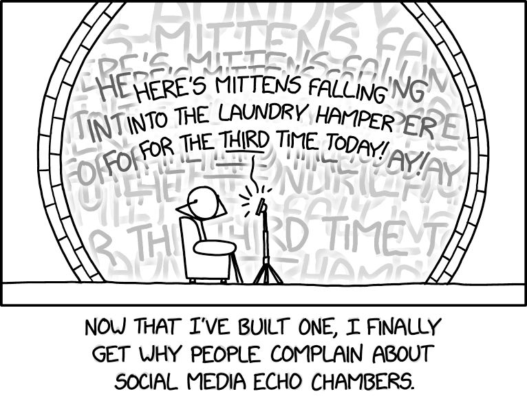 Comic. [Person sitting in a chair and covering ears with hands in front of a device on a stand in a circular chamber. Words coming from device are repeated endlessly.] Here’s Mittens falling into the laundry hamper for the *third* time today! [caption] Now that I’ve built one, I finally get why people complain about social media echo chambers. 