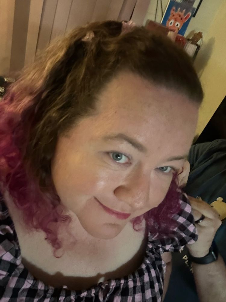 I’m wearing pink and lilac butterfly clips in my hair as I look up at the camera