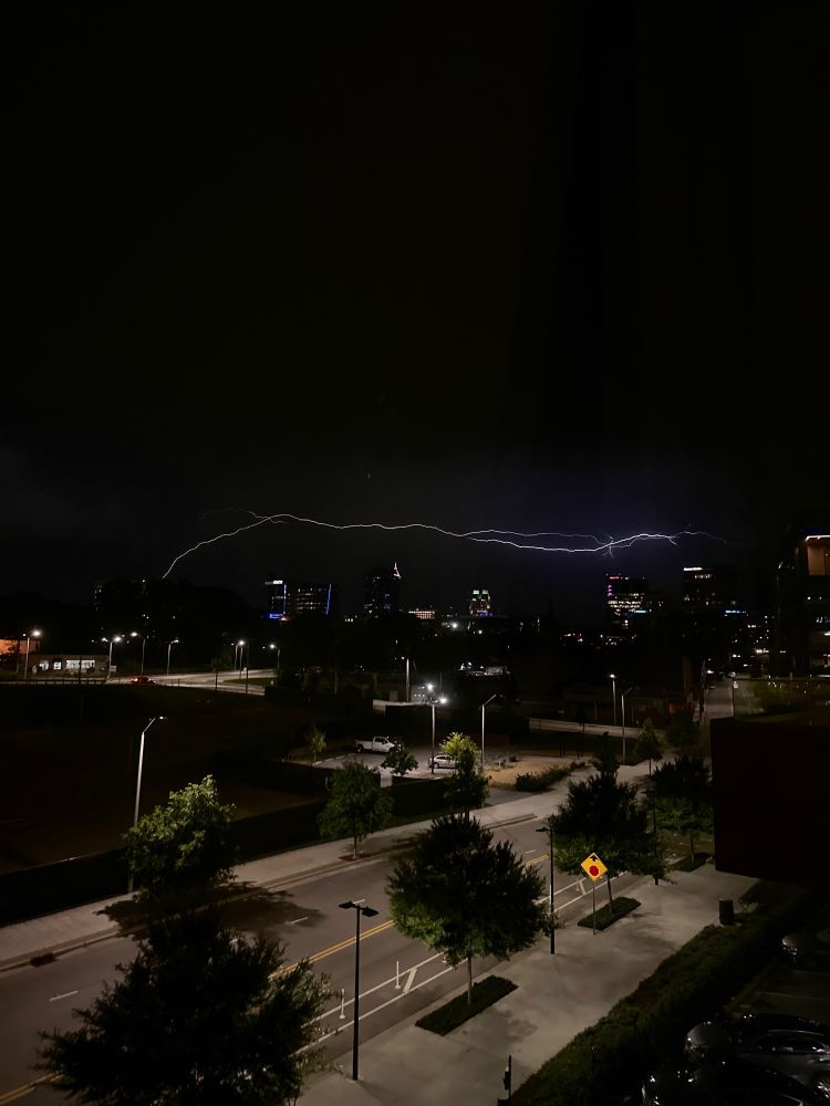 Image of downtown Raleigh, NC with a long horizontal bolt of lightning over the skyline.