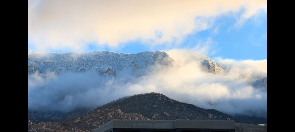 Clouds and snow on Sandia peak with some blue sky.