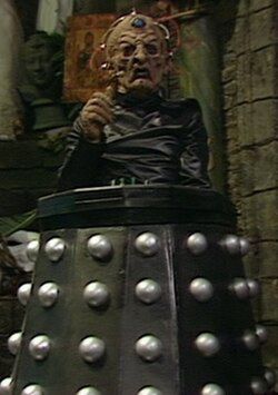 Davros, dalek leader hooked up to dalek body with wires and devoid of liquid inside his evil face