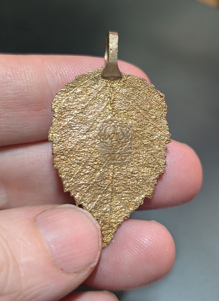 a bronze pendant in the shape of a birch leaf