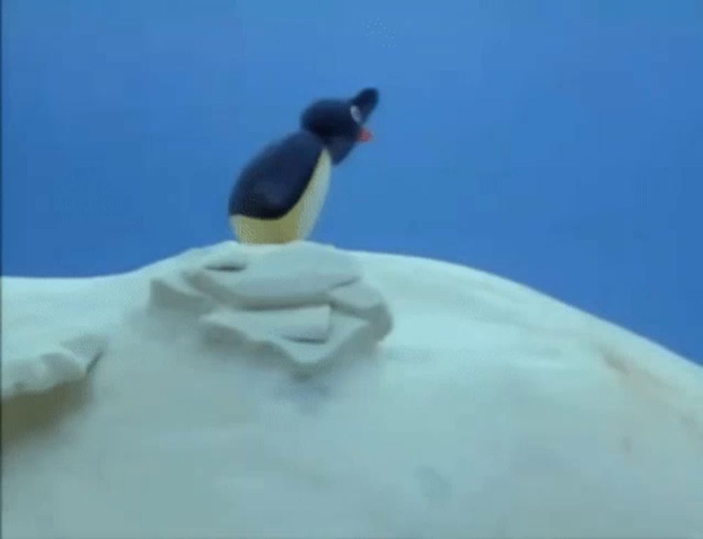 a cartoon penguin is standing on top of a snow covered hill .