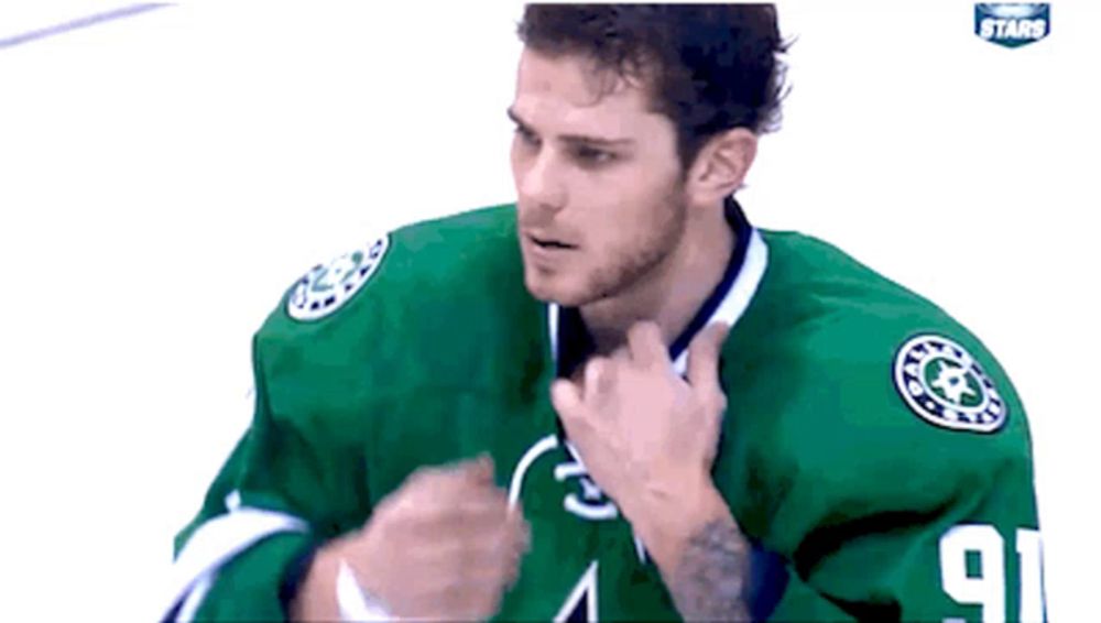 a hockey player in a green jersey with the number 91 on it