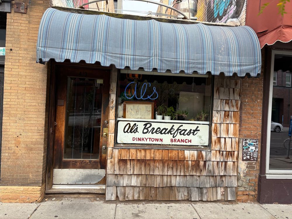 Al’s Breakfast - Dinkytown Branch, a restaurant front in Minneapolis, MN with cedar shakes and faded blue overhang
