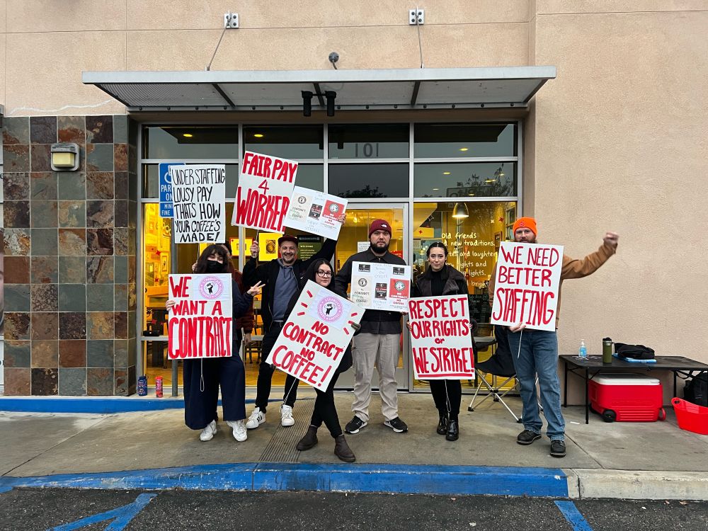 buncha strikers pose out front of the HB sbux with picket signs
