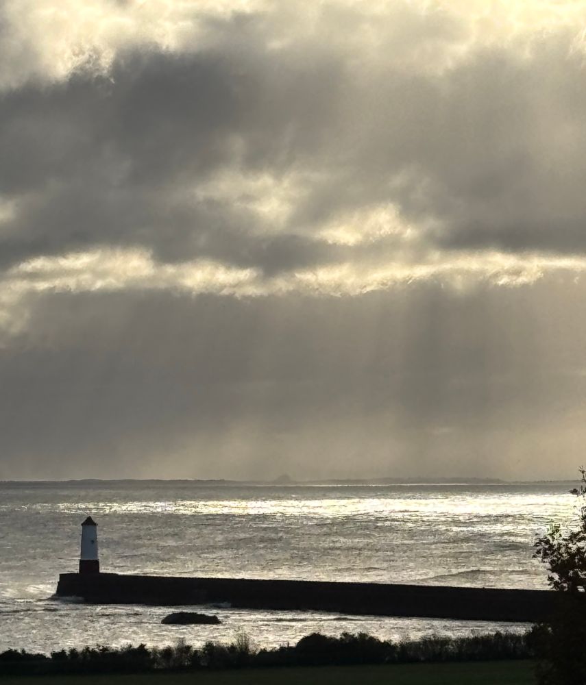 Lighthouse with god rays on overcast day