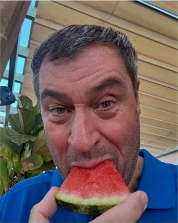 Markus Söder stopft sich ein Stück Melone in die Fresse.