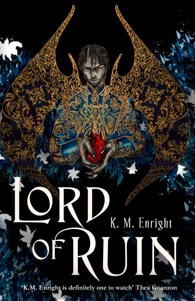 Cover for LORD OF RUIN by K. M. Enright. Black cover, with a dark haired Filipino man in a Gothic style embodied suit jacket in shades of blue and gold. Black wings with a similar gold embroidered design stretch behind him against a background of blue with white flowers. His hands are tipped in black talons and he holds a bright red anatomical heart. Blurb from Thea Guanzon — ”K. M. Enright is definitely one to watch.”  