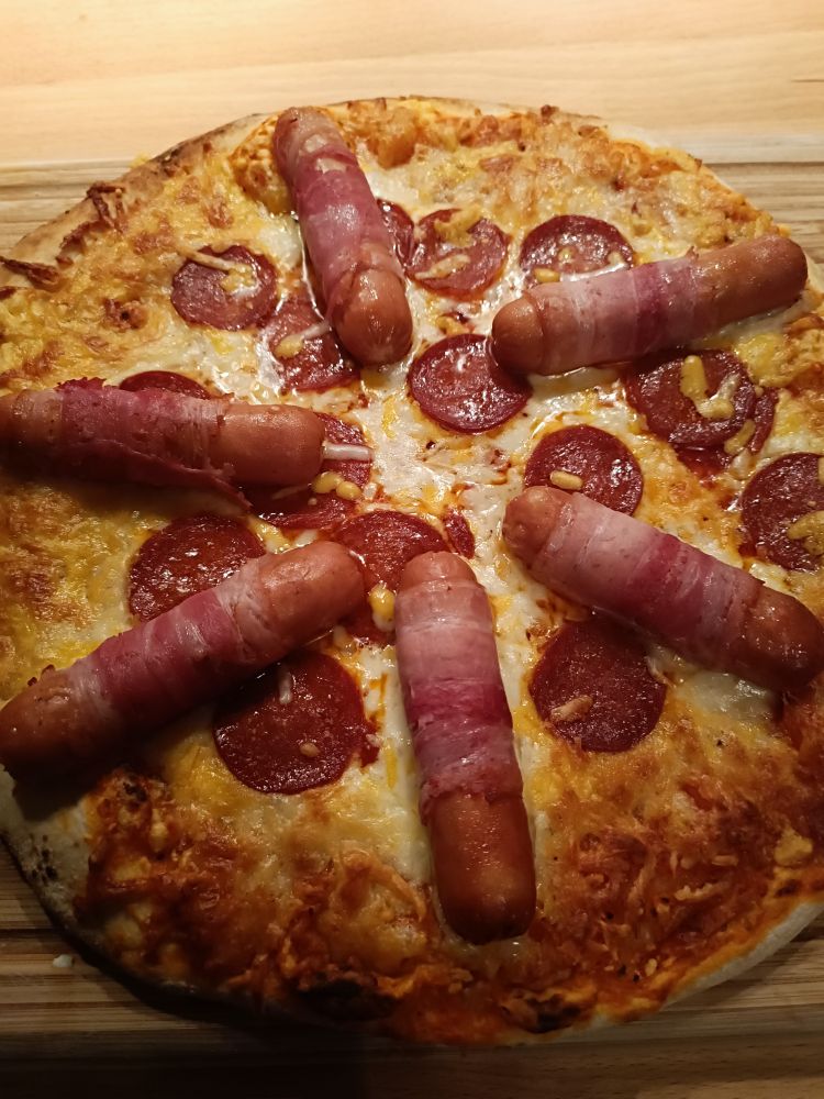 Bild einer Salamipizza mit Berner Würstchen sternförmig drauf arrangiert