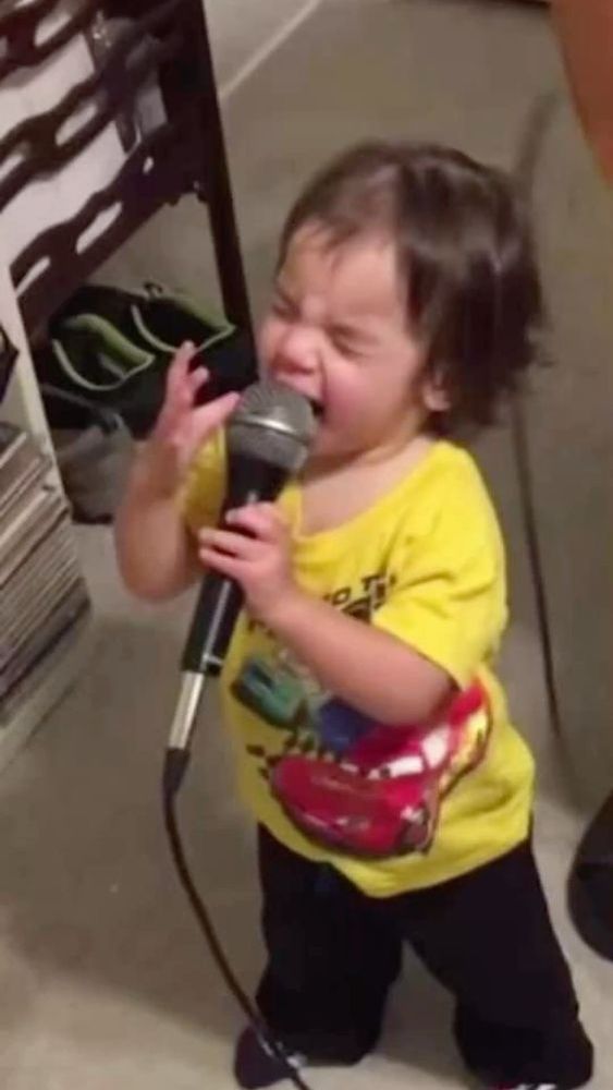 Picture of a little kid singing into a microphone absolutely giving their ALL. The presence the pose the passion. 
