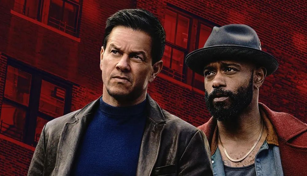 poster for the film PLAY DIRTY, showing a white man in a brown leather jacket and blue sweater, and a black, bearded man wearing a red coat and denim shirt and a hat, standing in front of an apartment building bathed in red. 