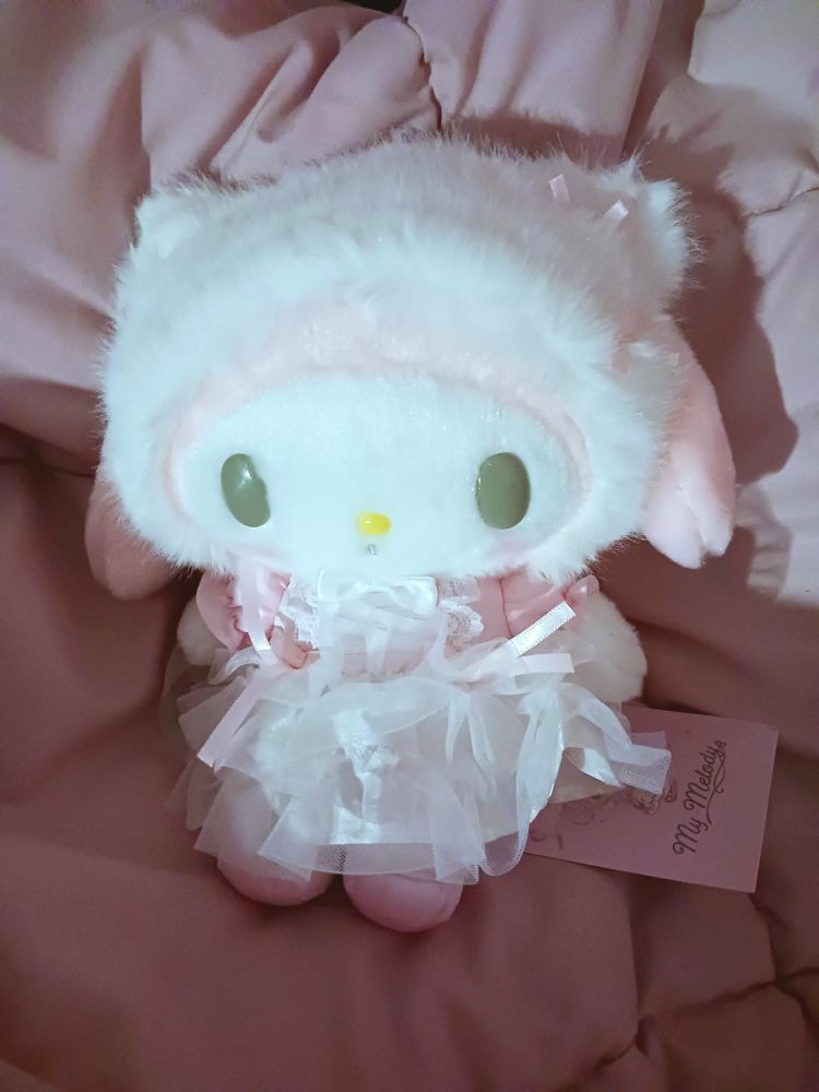 A ballet-themed My Melody Sanrio plush toy sitting on a pink blanket.