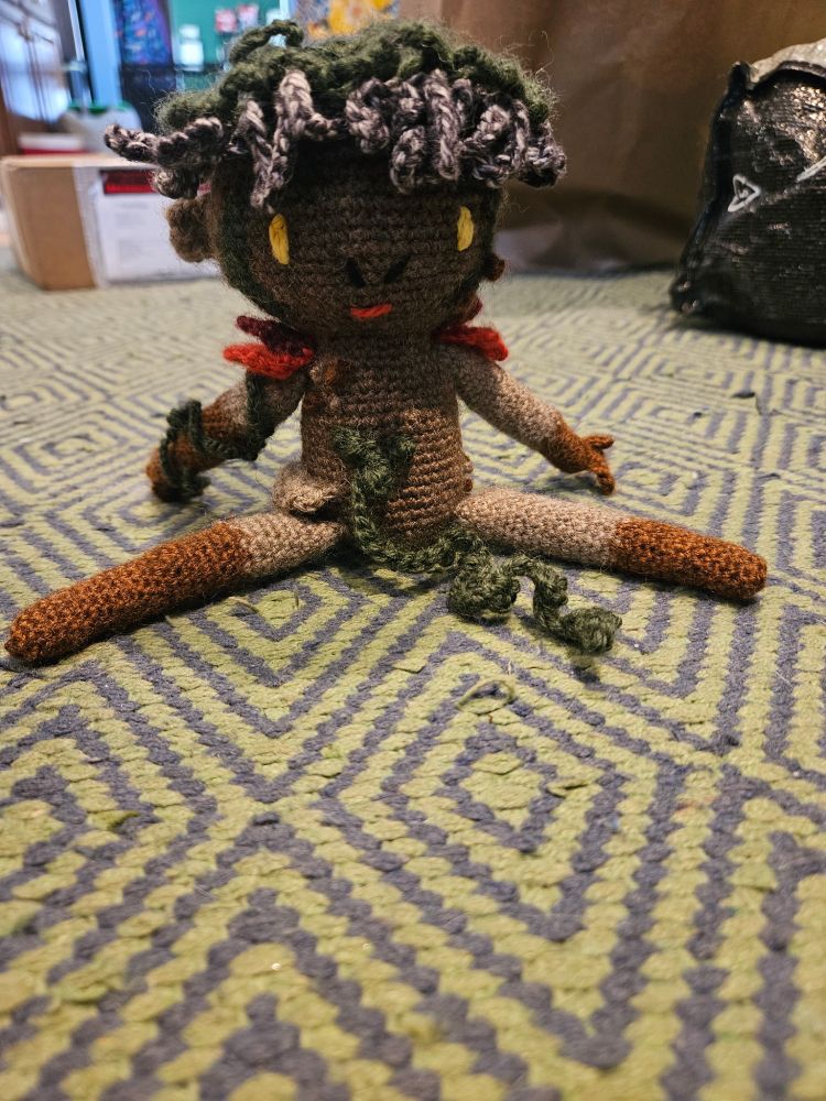 Picture of a crochet Adne Sadeh vegetable man sitting down