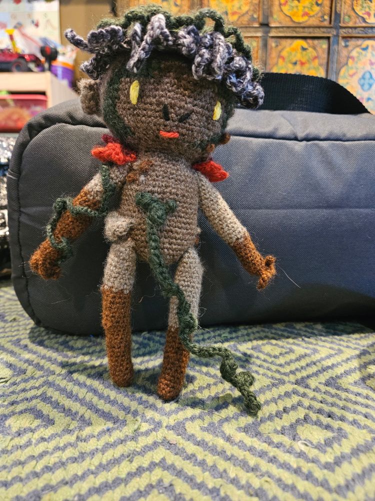 Picture of a crochet Adne Sadeh vegetable man standing up with a vine coming out of it's navel