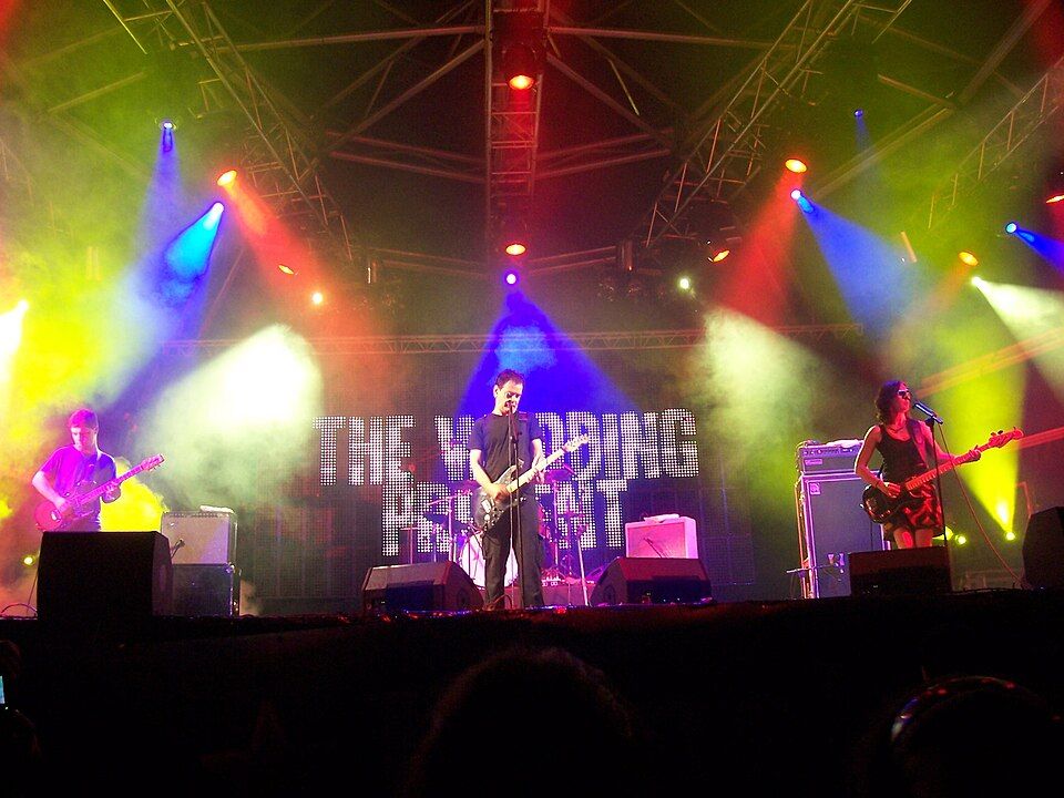 Photo of The Wedding Present performing on a stage with colorful lights