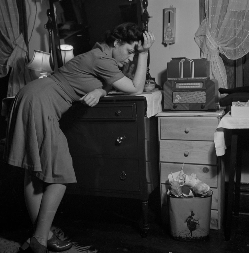 A woman still dressed in her work attire leans on her dresser as she listens intently to a murder mystery on her radio. An overflowing waste basket sits on the floor of her boardinghouse room. This is one of the images in Bubley’s photo essay on “Life in a boardinghouse in Washington, D.C.,” which she photographed in her sister’s building in 1943.