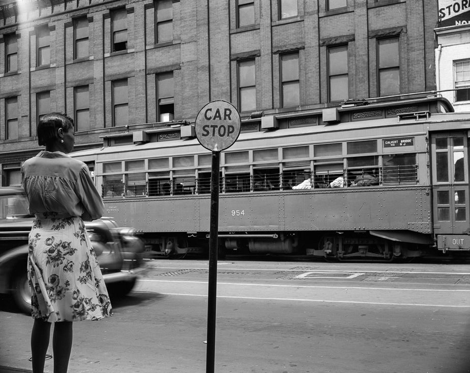 Car stop: Gordon Parks photographed a woman waiting for a streetcar in Washington, D.C., in August 1942. Standing next to a “Car Stop” sign, she observes the 954 streetcar going by in front of her, with an automobile blurred in motion just to her left. Parks made the image at 7th Street and Florida Avenue N.W.