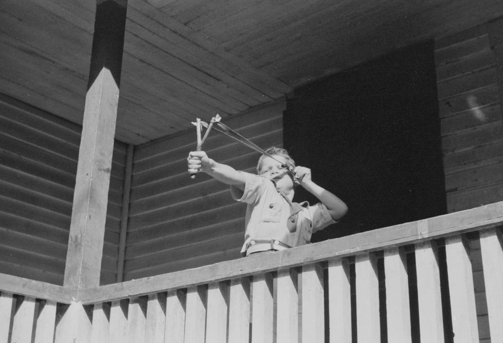 Slingshot boy: A young boy pulls on a homemade slingshot with all his might. Marion Post Wolcott photographed the action in September 1940 in the Kentucky hills near Buckhorn.