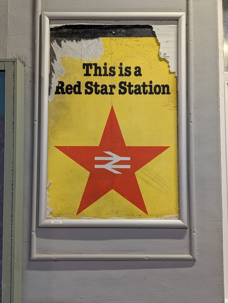 A yellow poster with a red star and the British Rail emblem in the middle.
A red star station it proclaims 