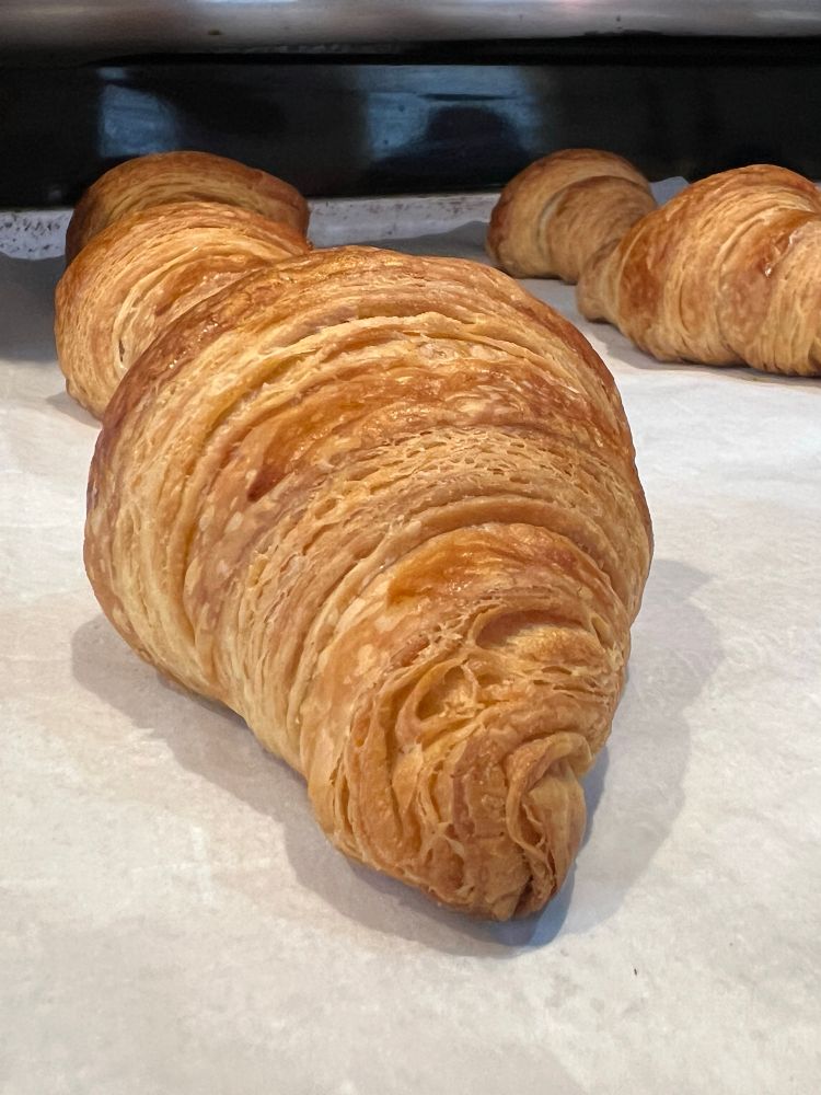 A side view of a croissant showing the lamination of the rolls